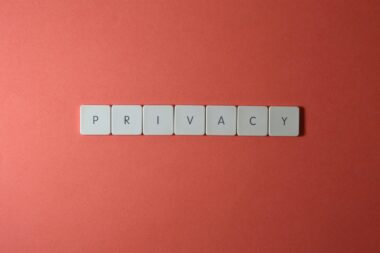 Close-up of letter tiles spelling PRIVACY on a red background, symbolizing data protection.